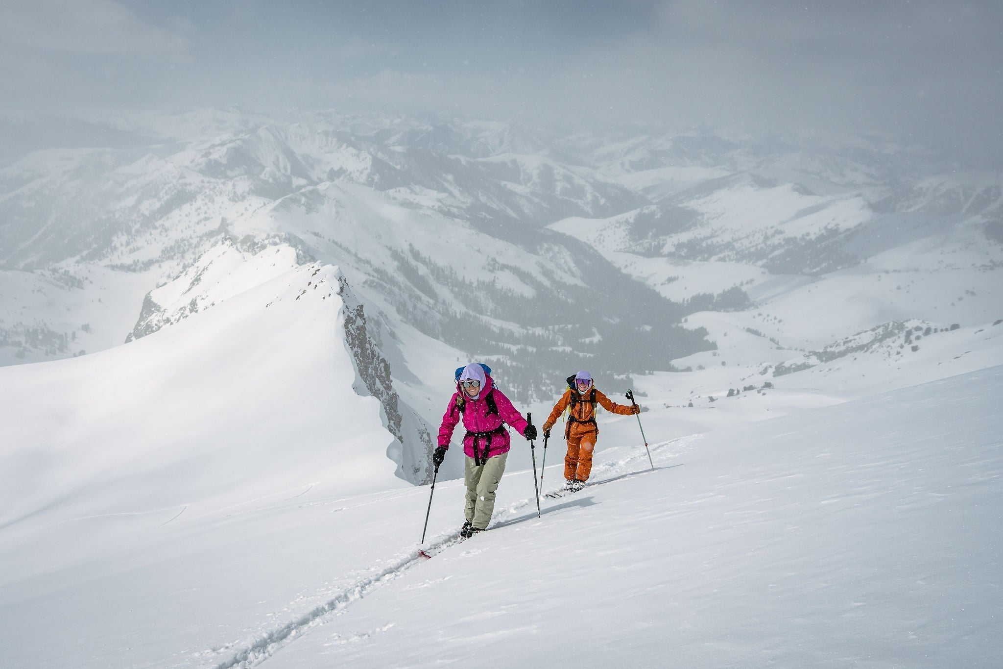 Two skiers ascending a snowy mountain landscape