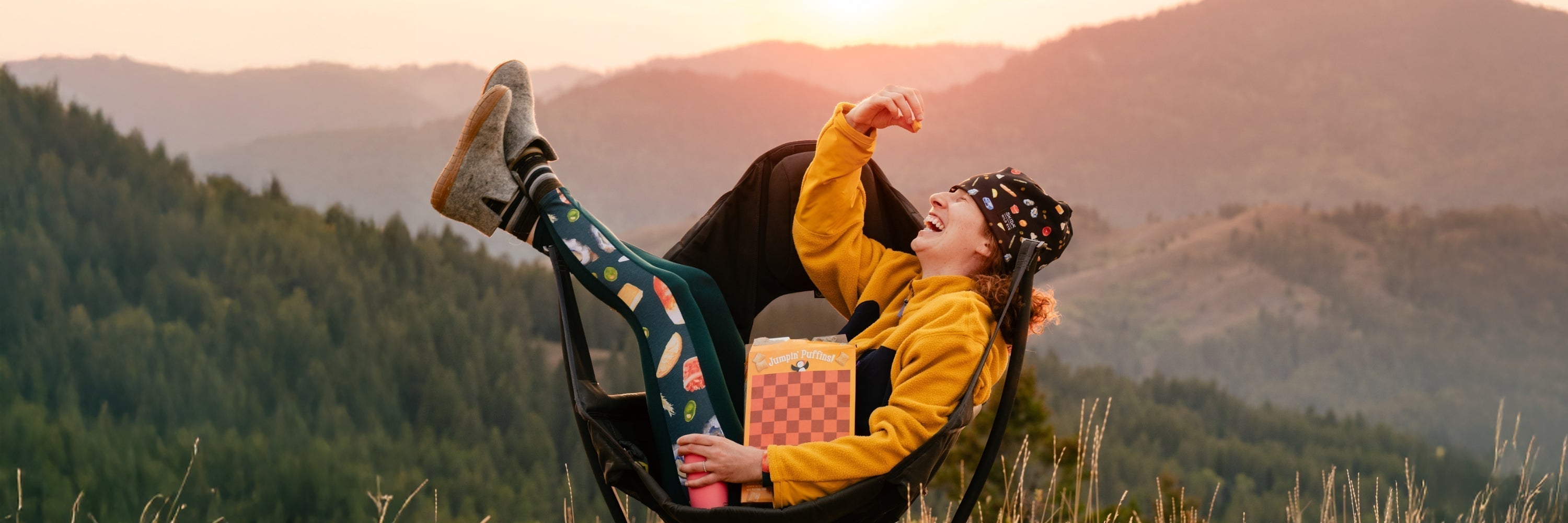 Person wearing a colorful floral cap with a label reading 'WILD RYE SKIDA', focusing on their hands and face as they handle a fishing line.