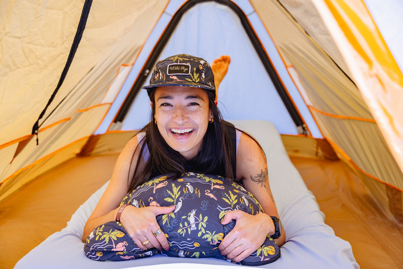 Woman laying on camping pillow in tent