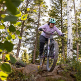 Woman Riding Mountain Bike Down Rocks