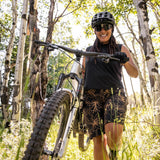 Woman carrying bike through the woods in freel bike short
