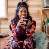 Woman wearing hailey half zip and drinking coffee