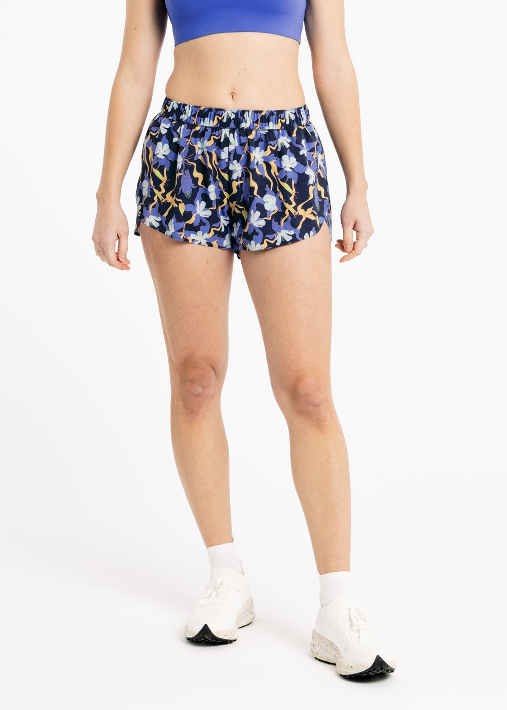 Person wearing blue floral shorts on a white background