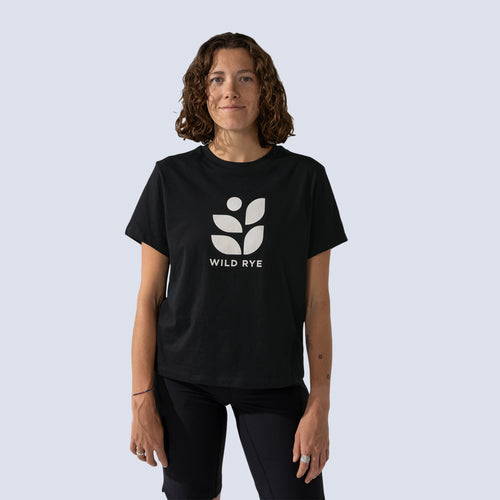 Woman wearing black t-shirt with large white 'Wild Rye' logo printed on front, closer view