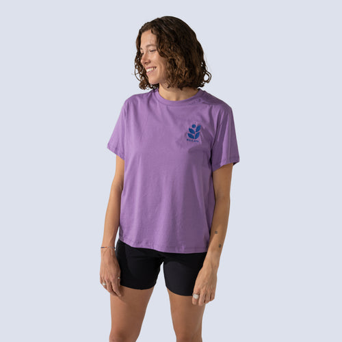 Woman wearing purple t-shirt with an embroidered wild rye logo on chest