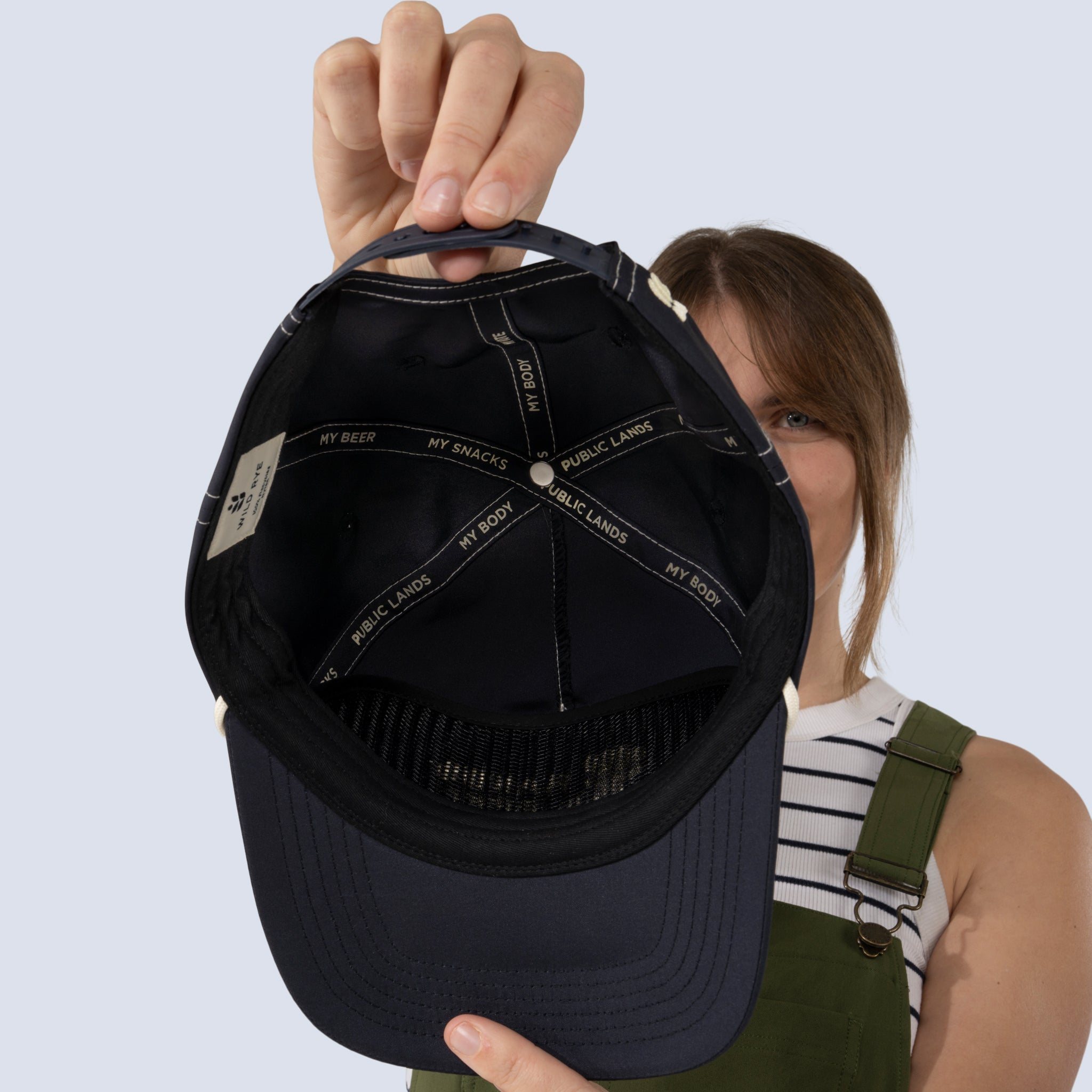 Inside of hands off trucker hat showing "my body, my snacks, my beer, public lands" writing inside