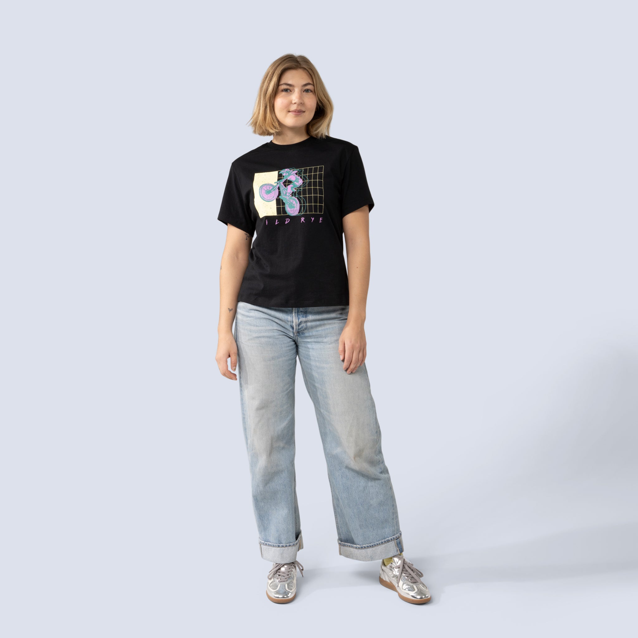 Person wearing a black t-shirt with a graphic design and light blue jeans on a white background