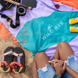 Wild Rye camp towel in happy hour laid out on the beach