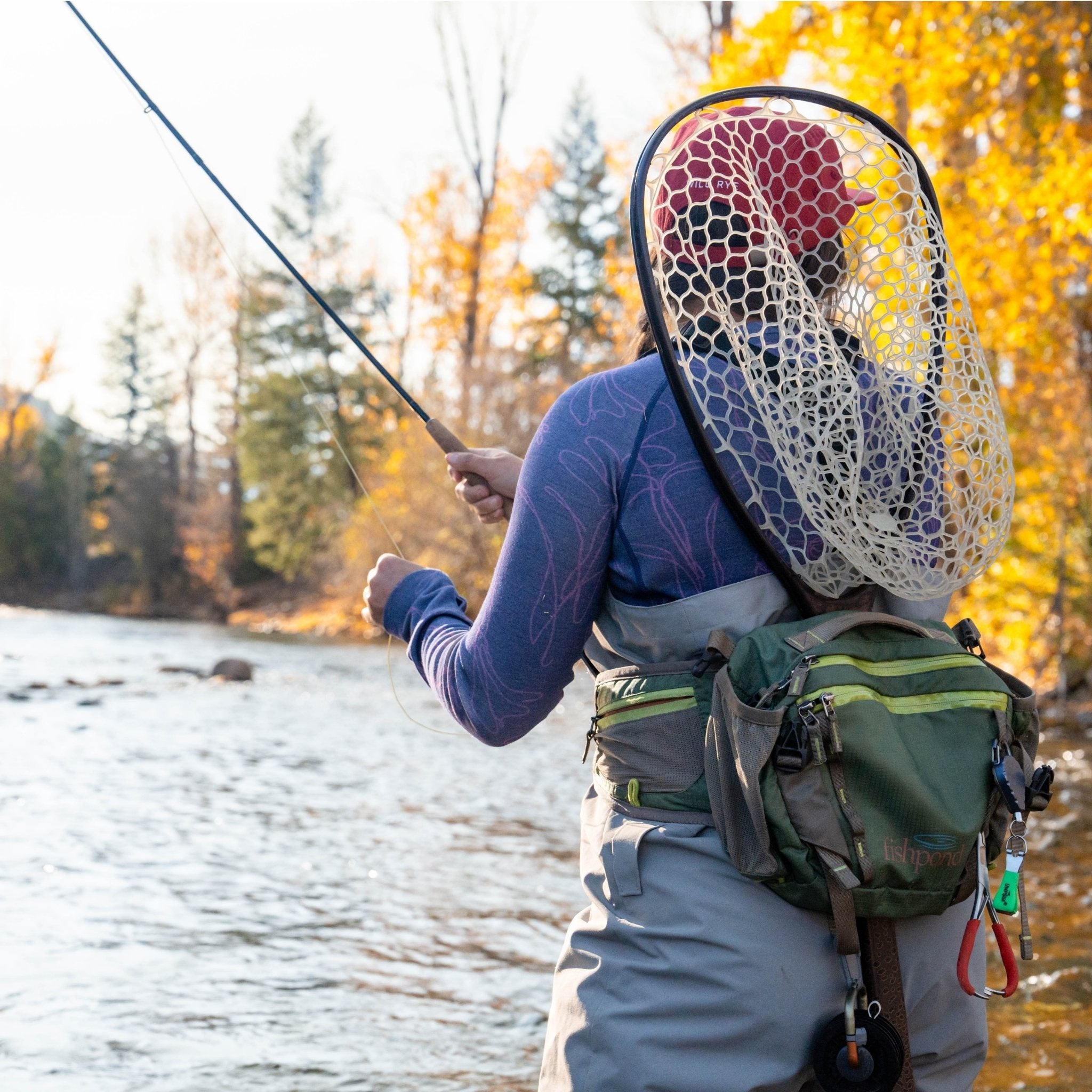 [Storm Contour] Person fly fishing by a river with autumn trees in the background