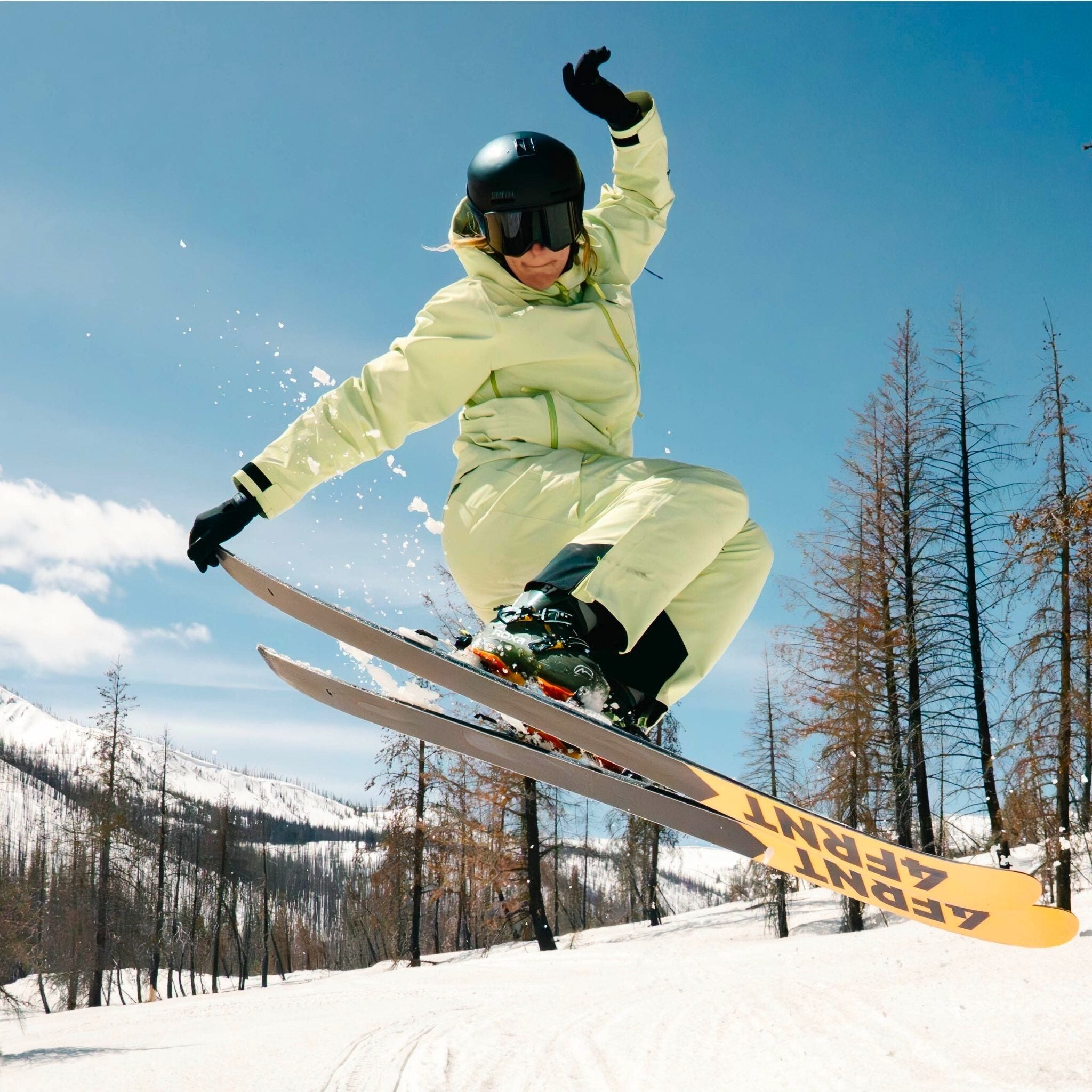 [Iced Matcha] Skier hitting a jump in the backcountry, wearing an iced matcha butterfield ski kit
