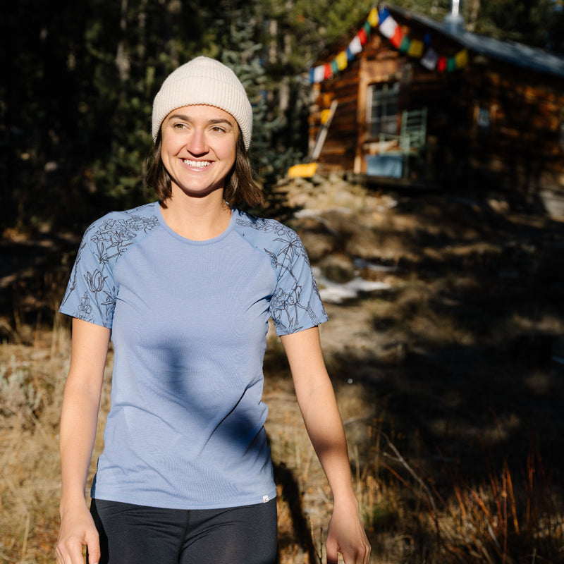 Woman Wearing Nona Lite Short Sleeve Top Alpine Bloom At Cabin