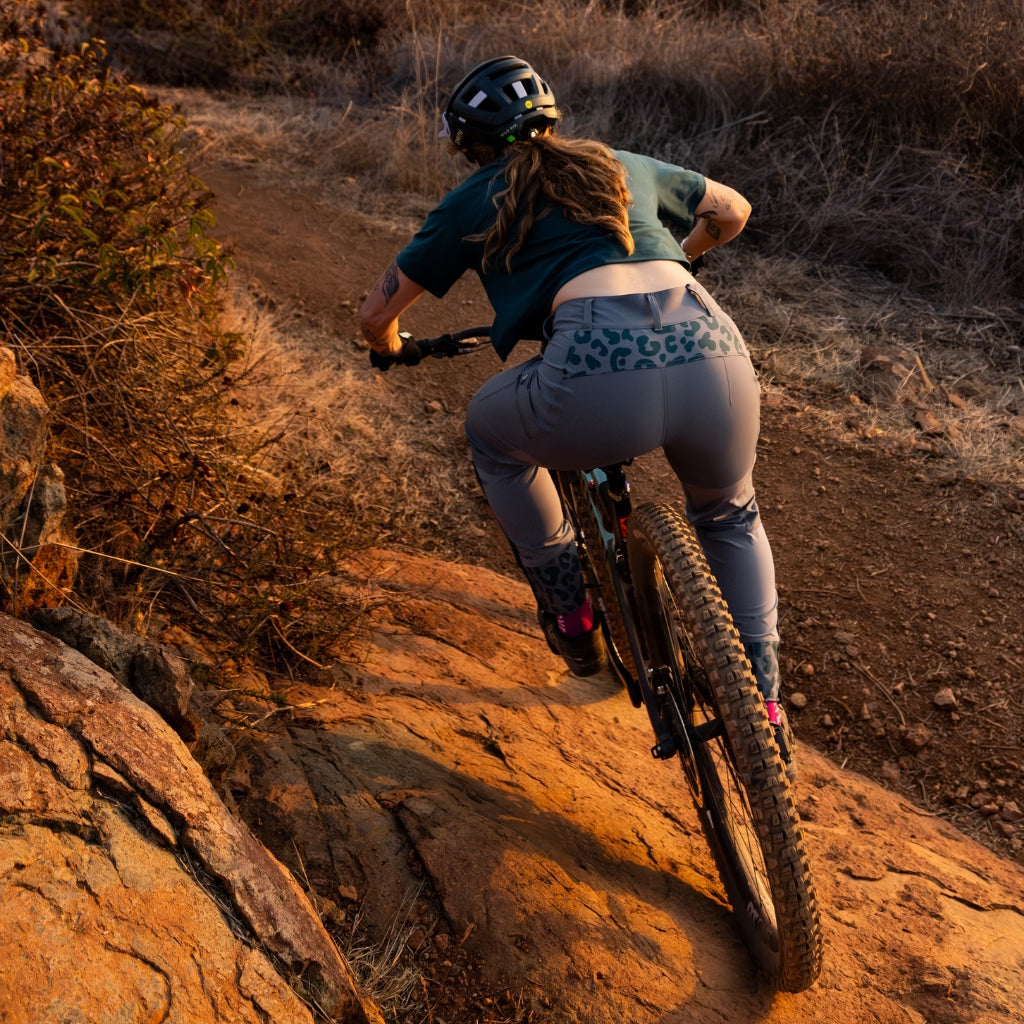 [Steel] Woman downhill mountain biking at sunset in freyah pant steel