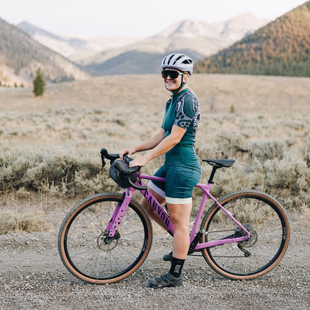 [Spruce Roots] woman riding gravel bike in smith x wild rye gravel kit