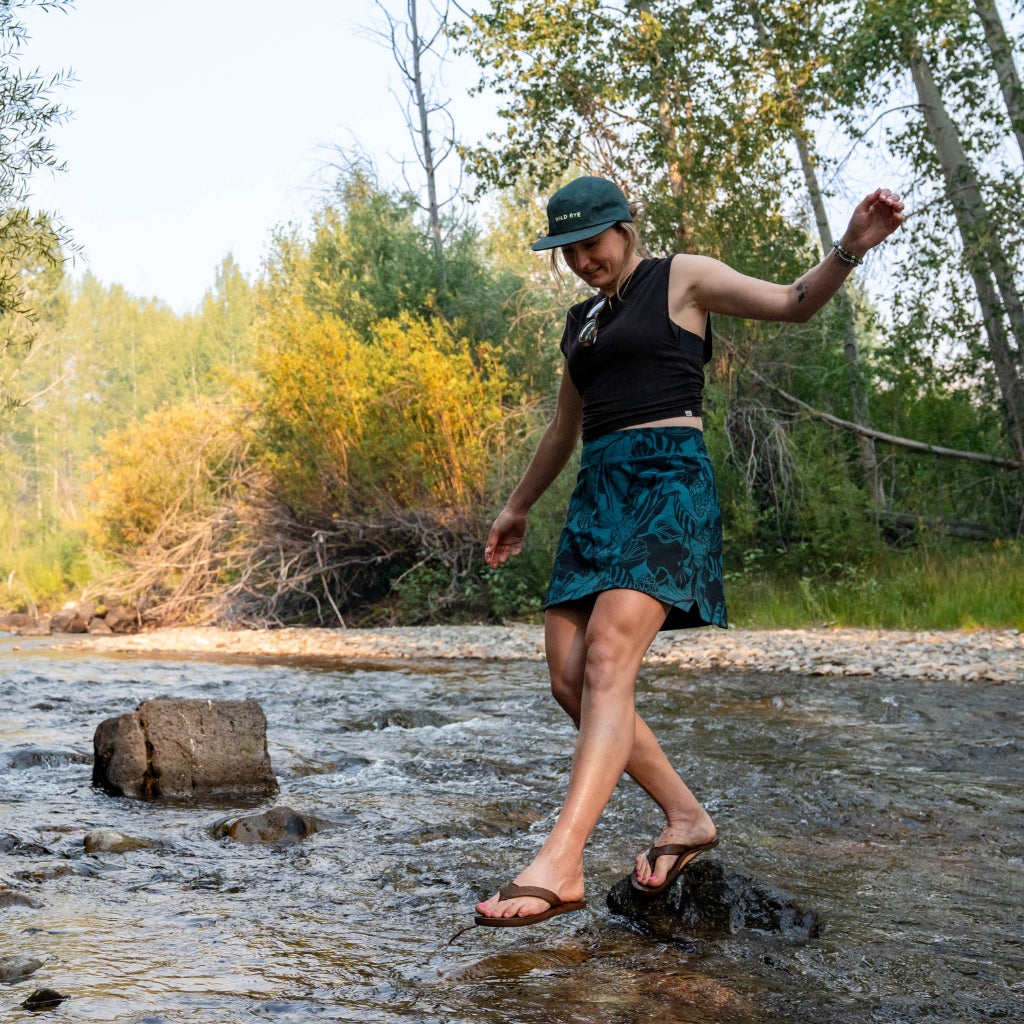 [Spruce Morchella] Woman walking over rocks through creek