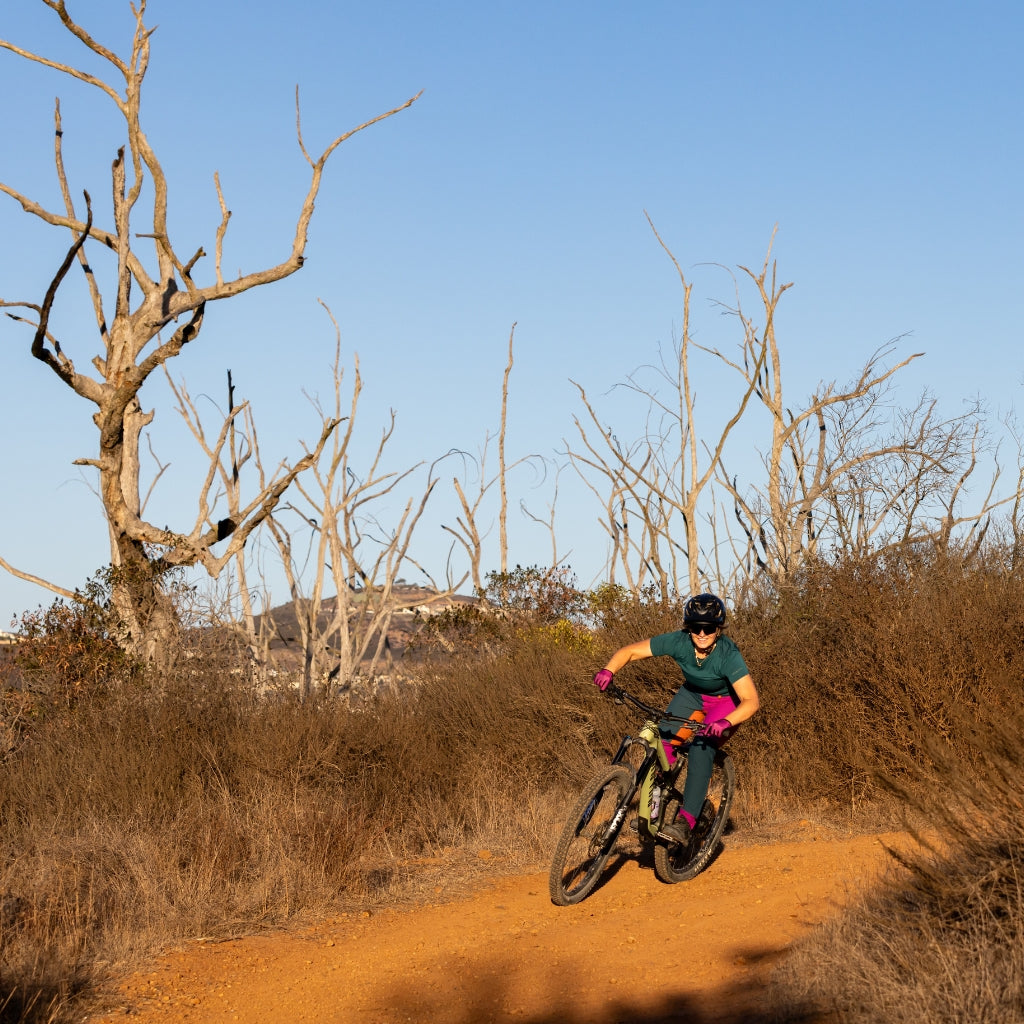 [Aster Blocked] Woman cornering on mountain bike wearing color blocked freyah pant