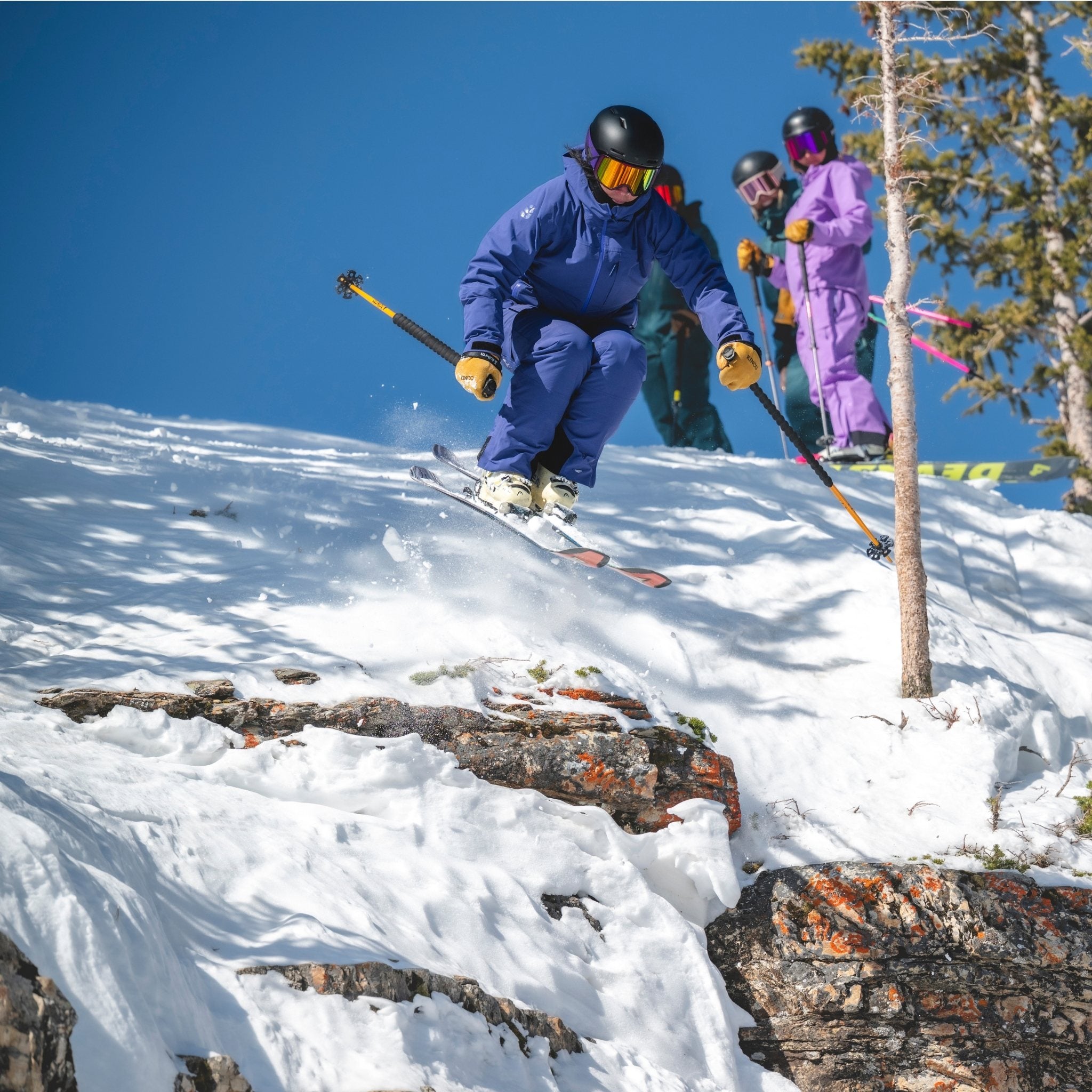 [Storm] Skier wearing a blue ski kit jumping off rock