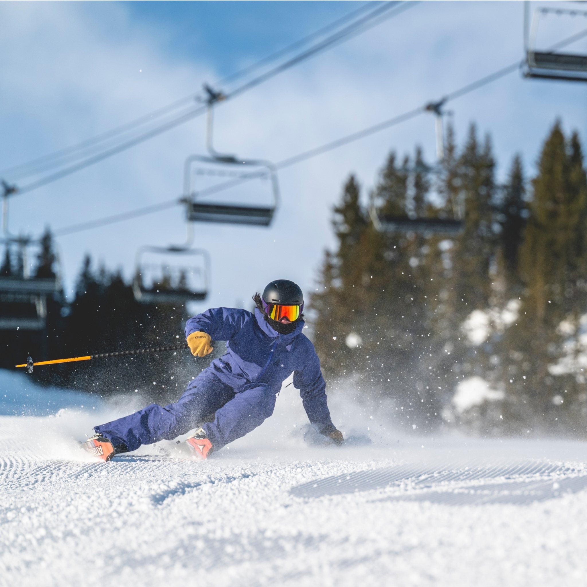 [Storm] Skier in blue ski kit, carving a turn on a groomed run