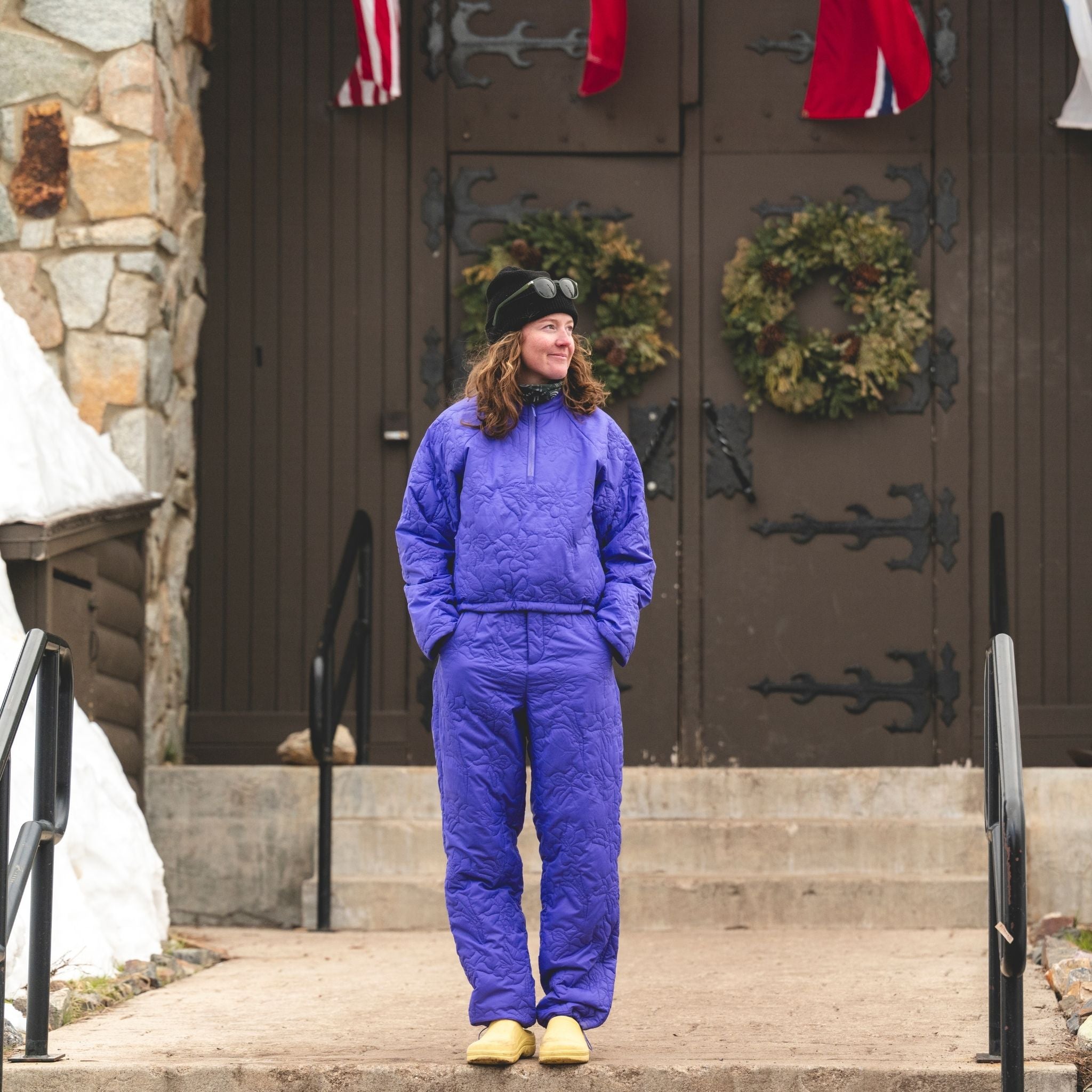 [Iris] Person wearing a matching Iris payette pullover and pant standing in front of a door with wreaths