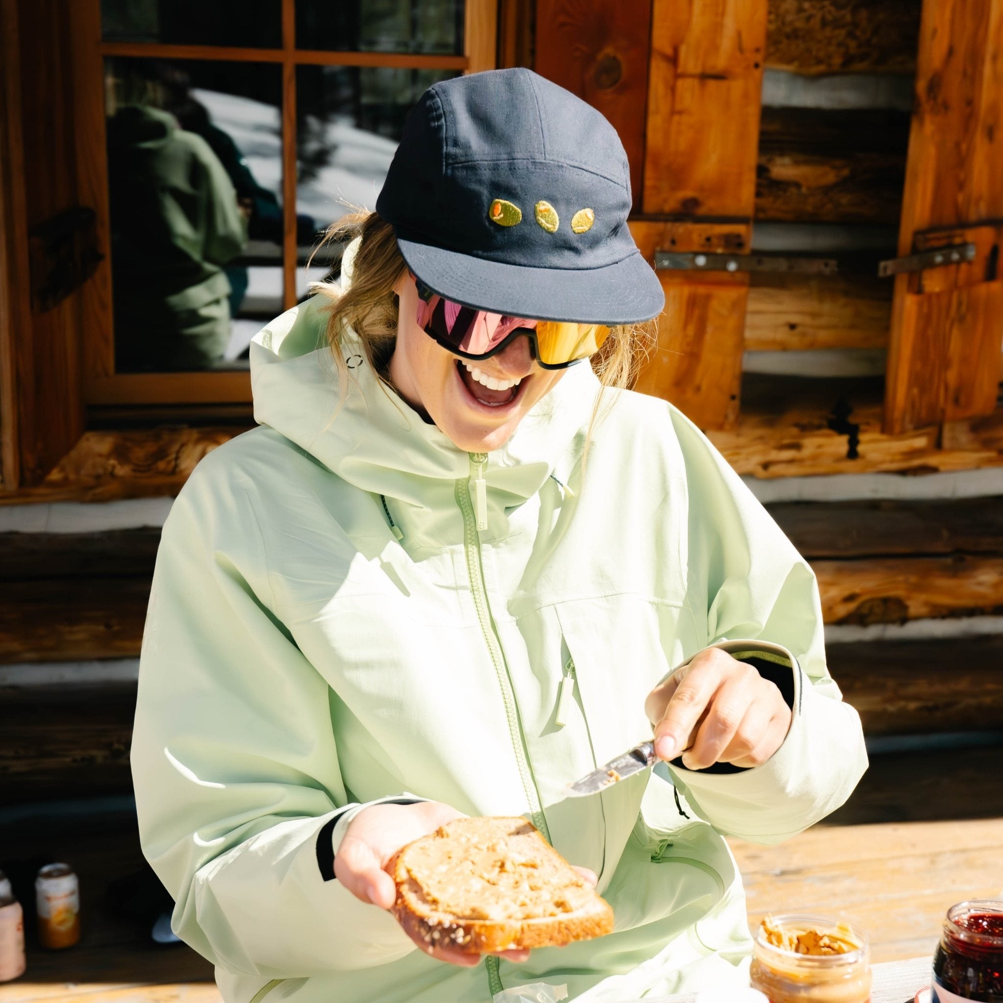 [Midnight Olives] Woman making a peanut butter and jelly sandwich at a backcountry hut