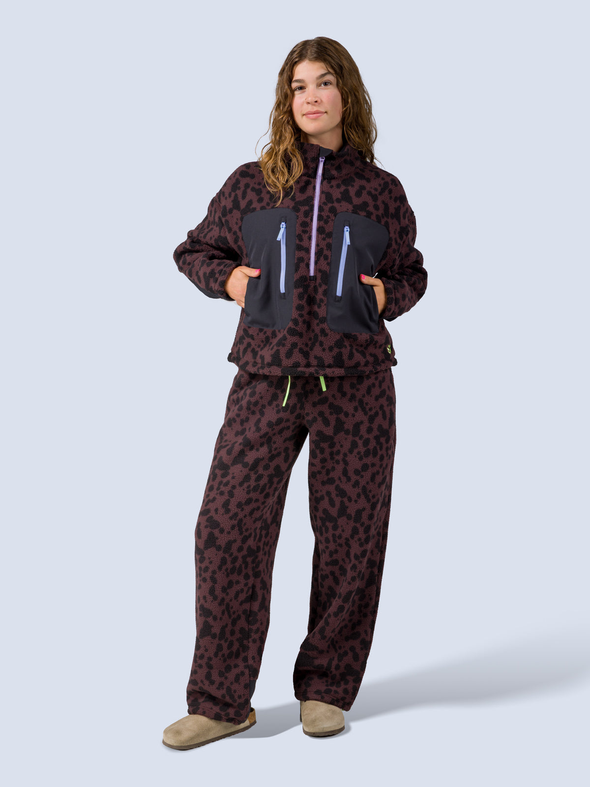 [Dapple] Model wearing the Banner Pant in brown leopard-print fleece with the matching zip jacket, full front view