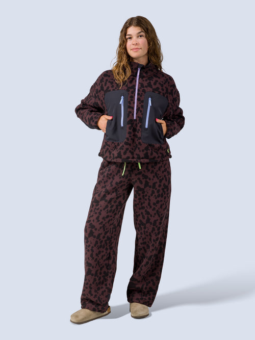 [Dapple] Model wearing the Banner Pant in brown leopard-print fleece with the matching zip jacket, full front view