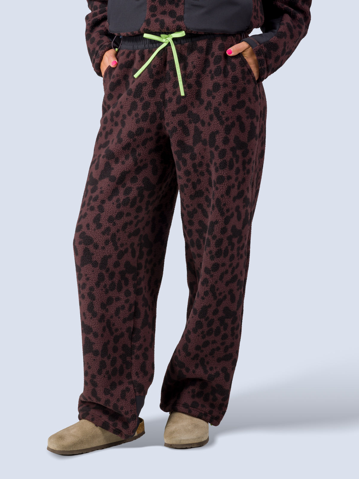 [Dapple] Close-up of the Banner Pant's elastic waistband and green drawstring in brown leopard-print fleece