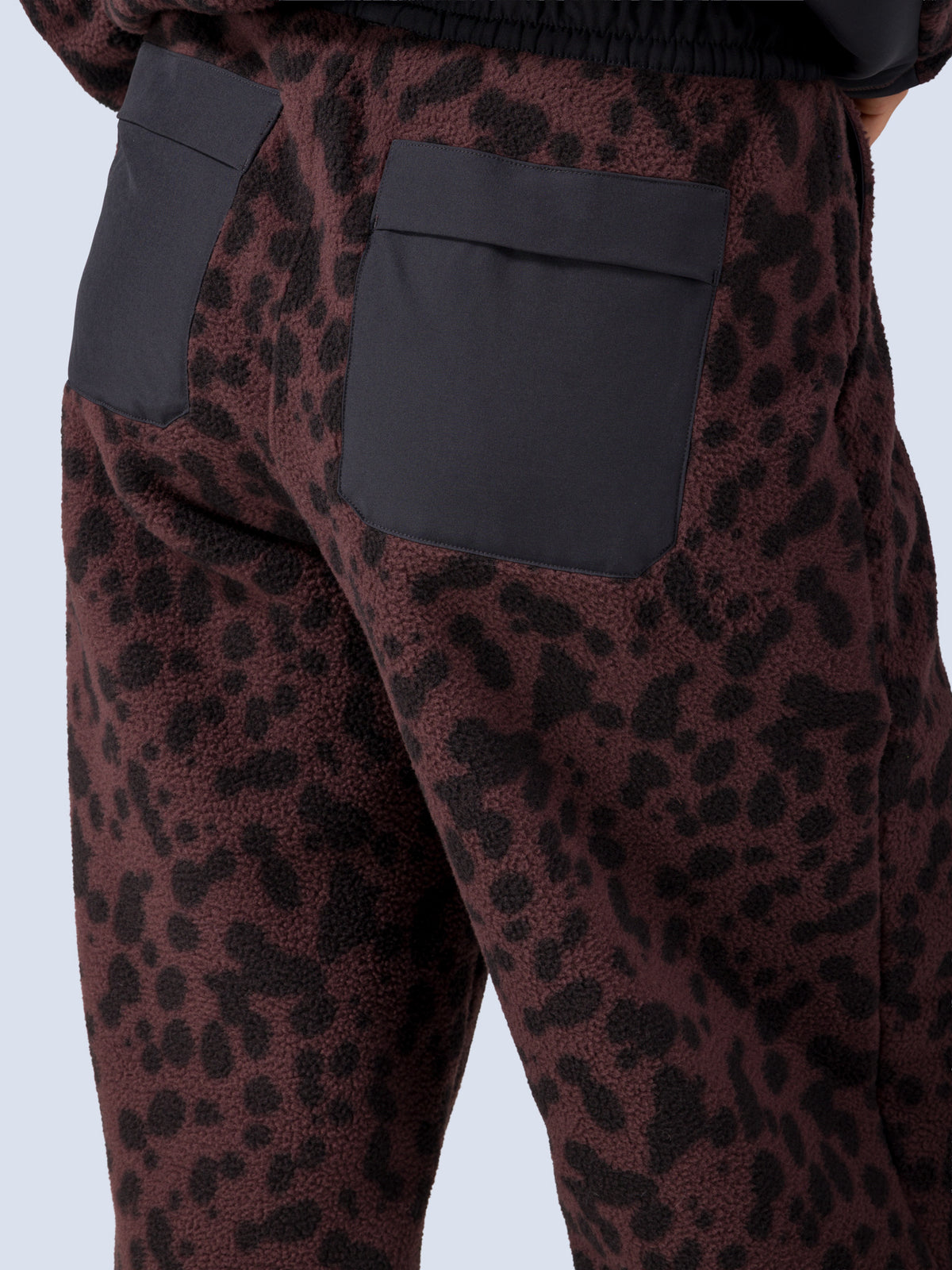 [Dapple] Detail shot of the Banner Pant's back patch pocket in brown leopard-print fleece