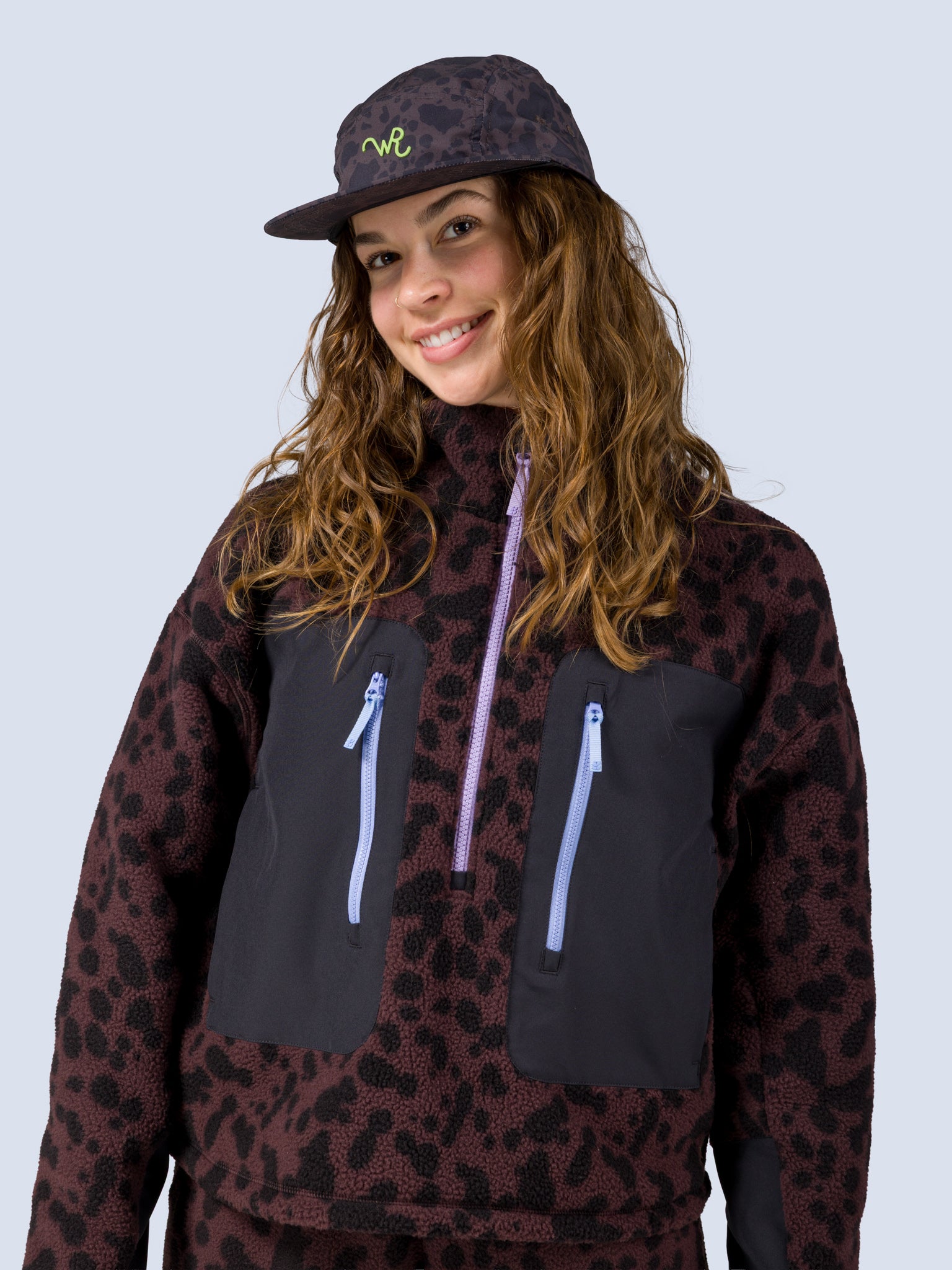 [Moo La La] Model wearing the Edith Brim Hat in a brown and black leopard-spot print with a green WR logo on the front panel, paired with the matching leopard-print zip jacket
