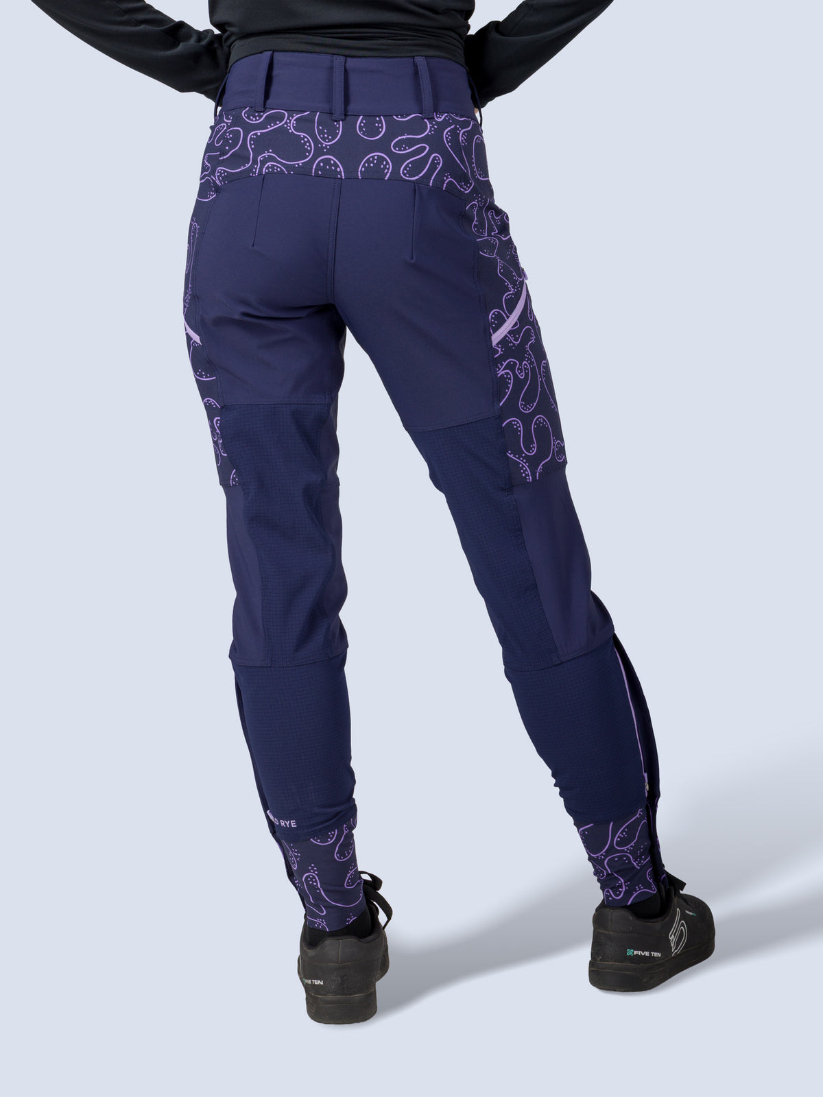 [Abyss Reef] Model wearing the Freyah Bike Pant in navy with a black long-sleeve top and helmet, full back view
