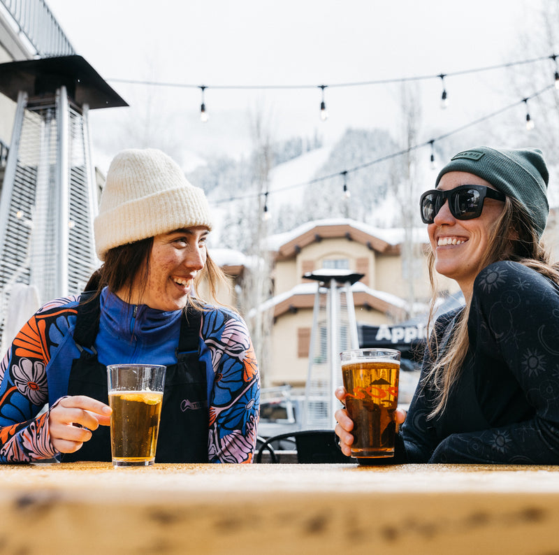 Women drinking beers at ski resort with merino wool baselayer tops