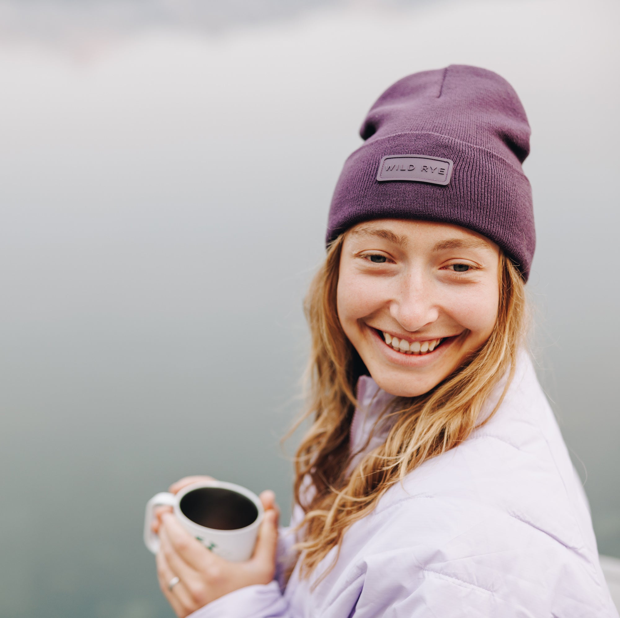 [Eggplant] Woman wearing purple beanie drinking coffee