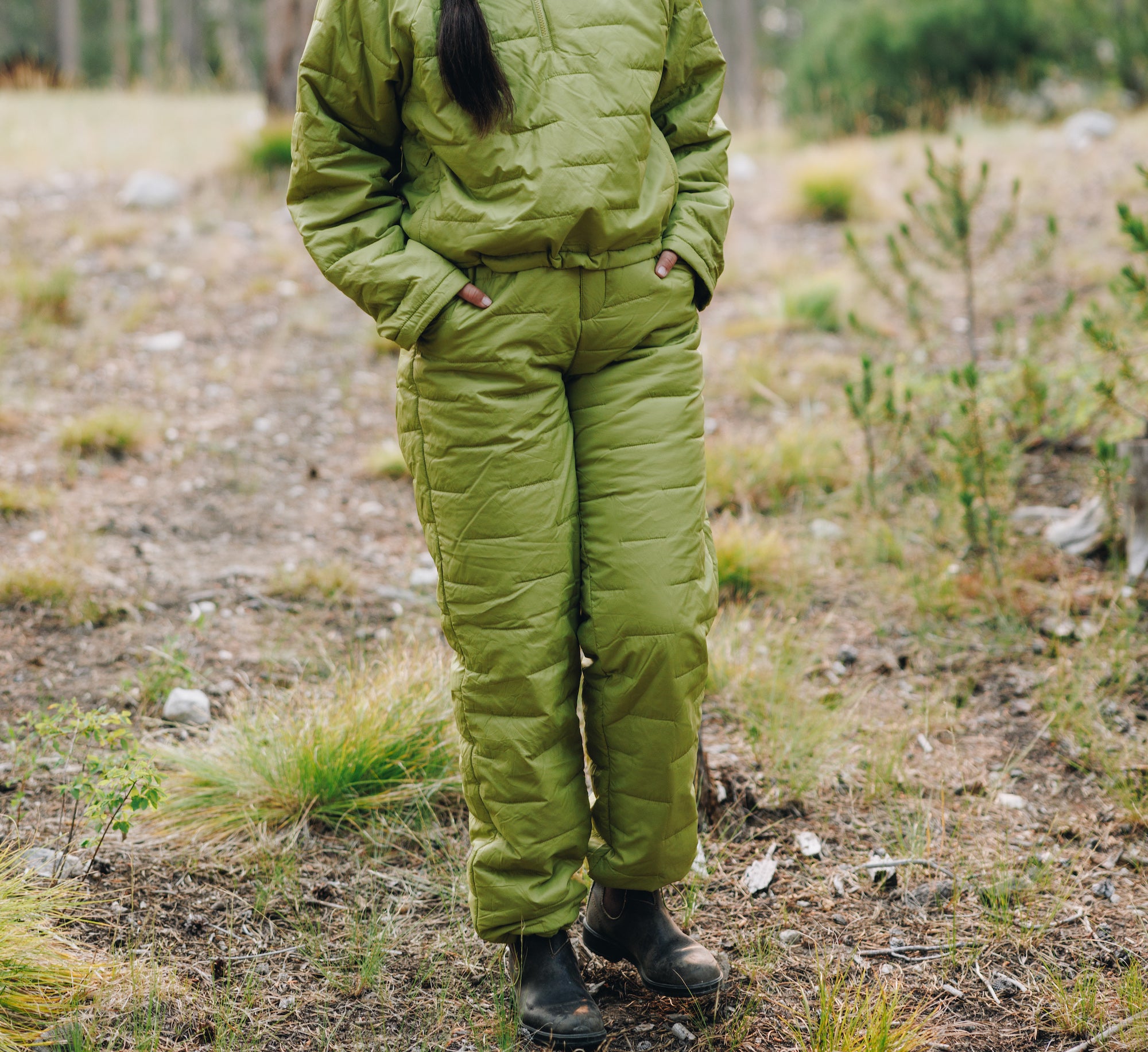 Woman wearing insulated pullover and insulated pants in the forest