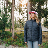 Woman wearing black insulated jacket with pink hat