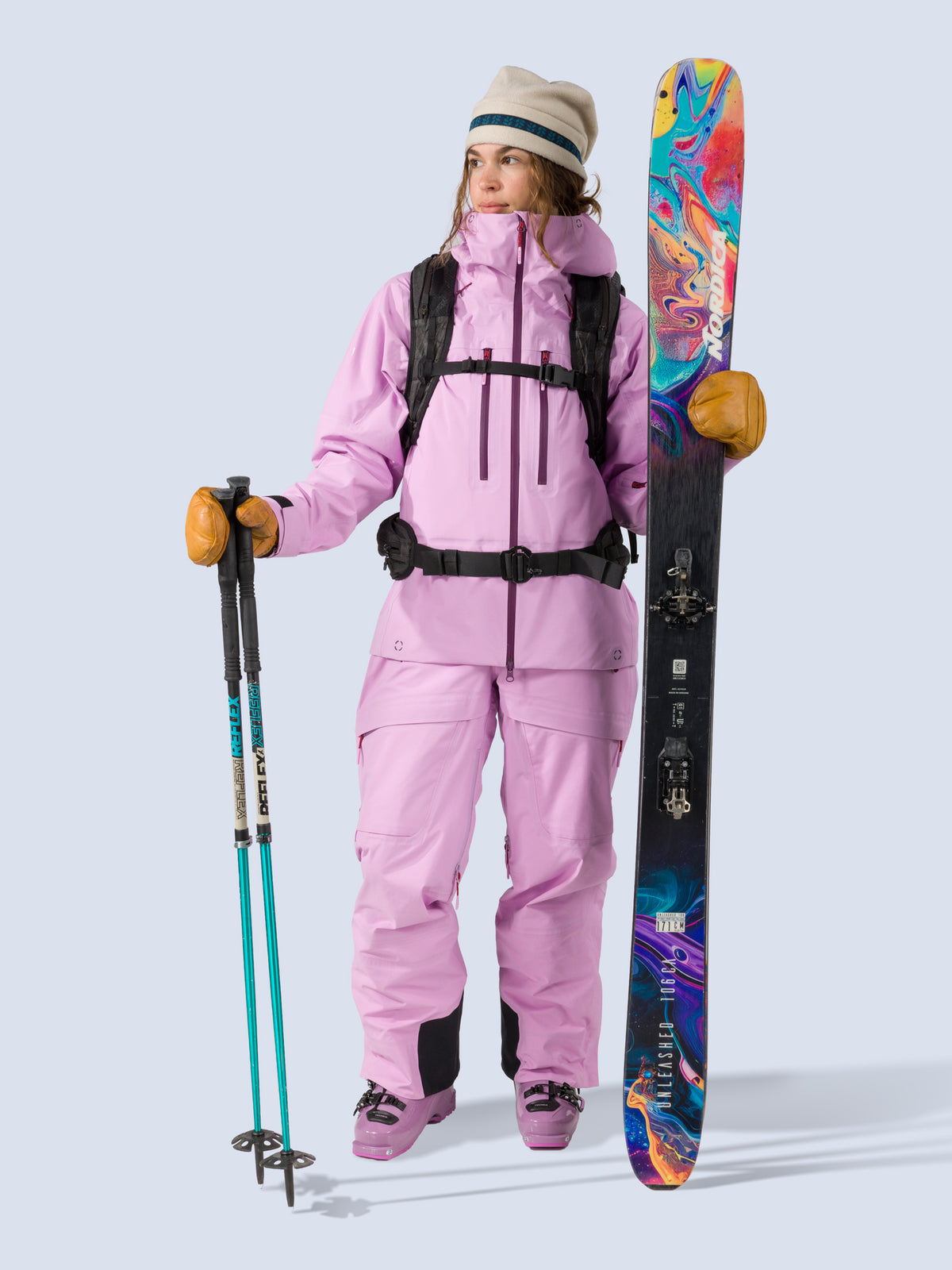[Orchid] Heyburn 3L Jacket in orchid pink, on model with skis and poles shot
