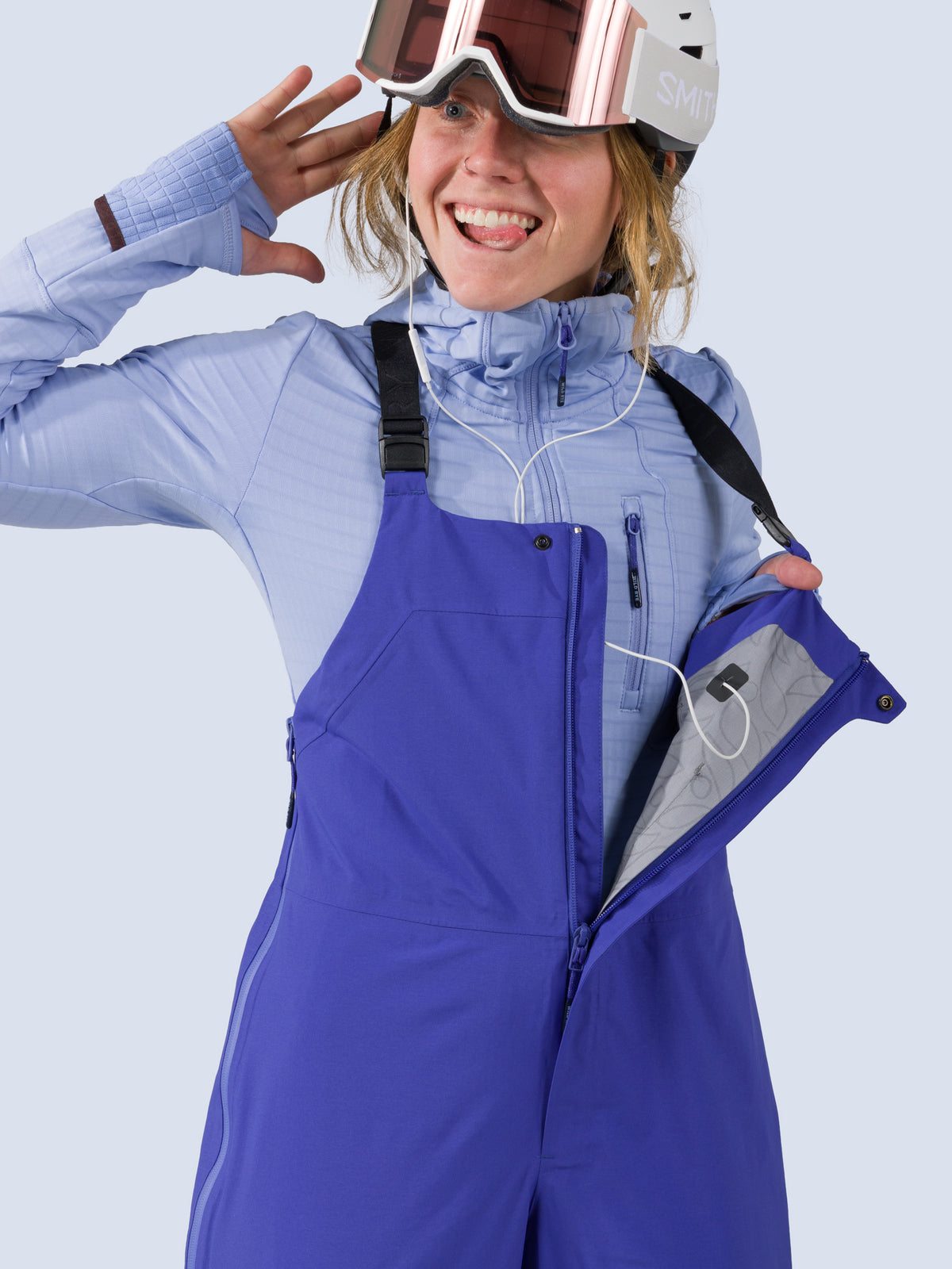 [Lapis] Heyburn 3L Bib in lapis blue, headphone port detail on front pocket