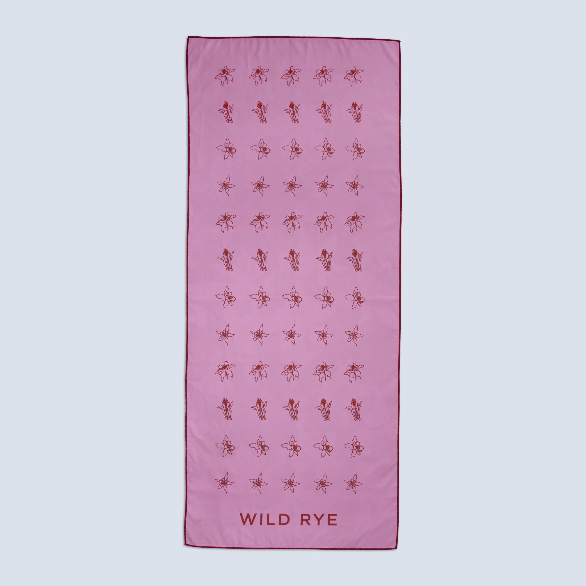 Quick-drying pink towel with red floral patterns and 'Wild Rye' branding