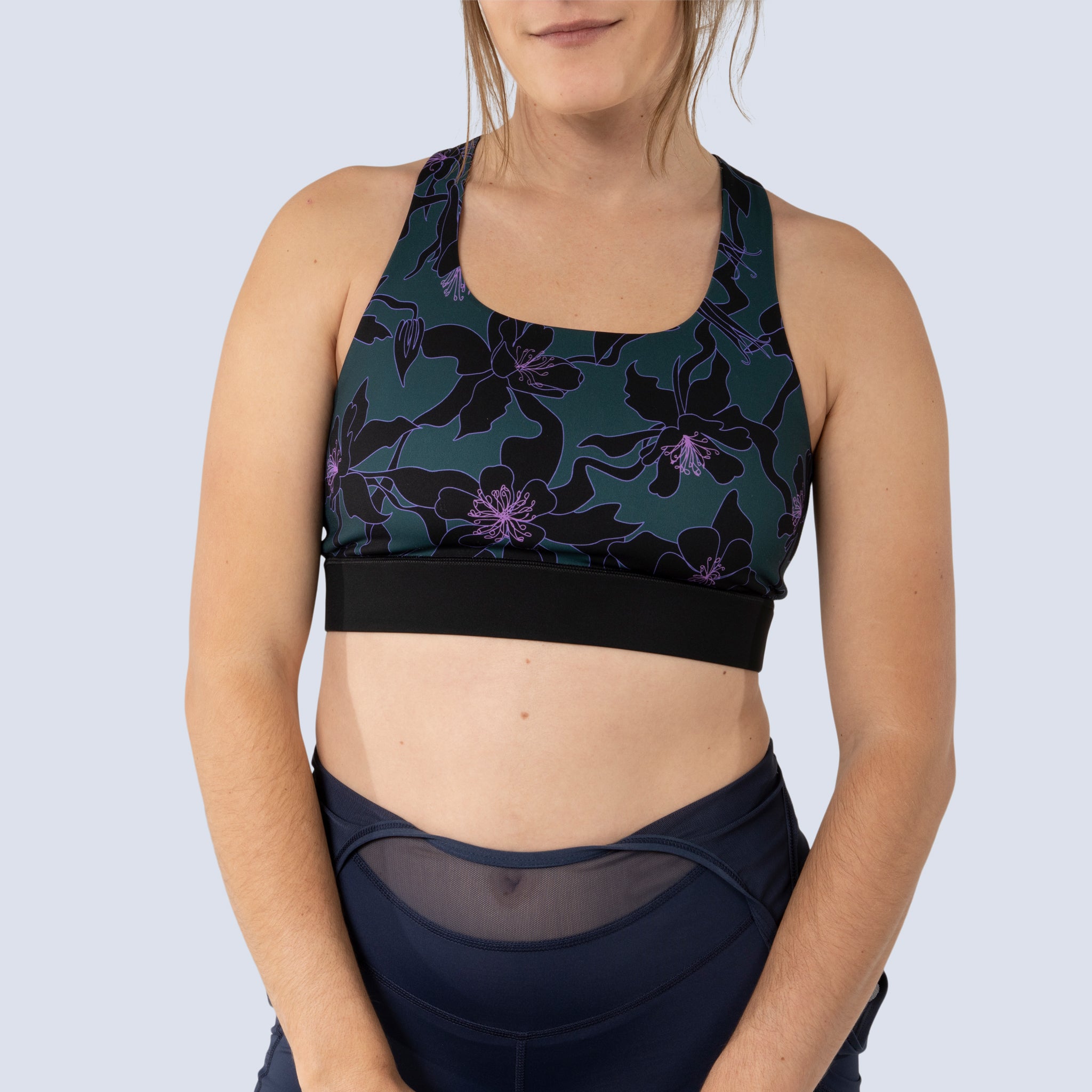 [Spruce Aquila Bloom] Lucille sports bra in green with black floral pattern, on model front crop view