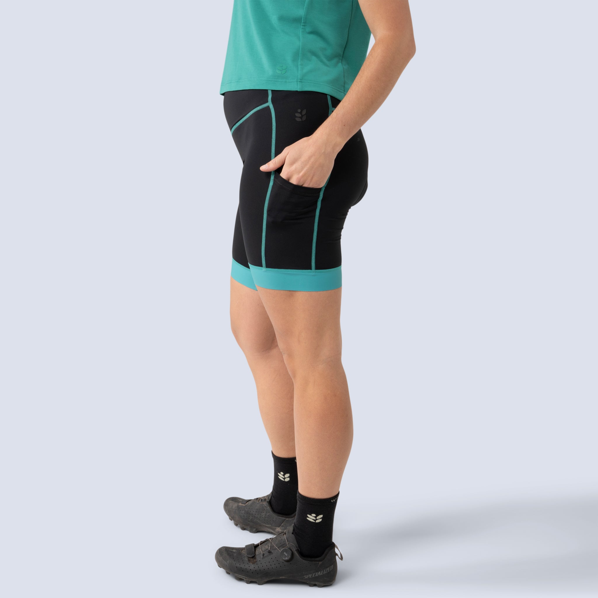 [Black Alhambra Blocked] Alyssa Chammy bike shorts in black with green leg bands, on model side crop view