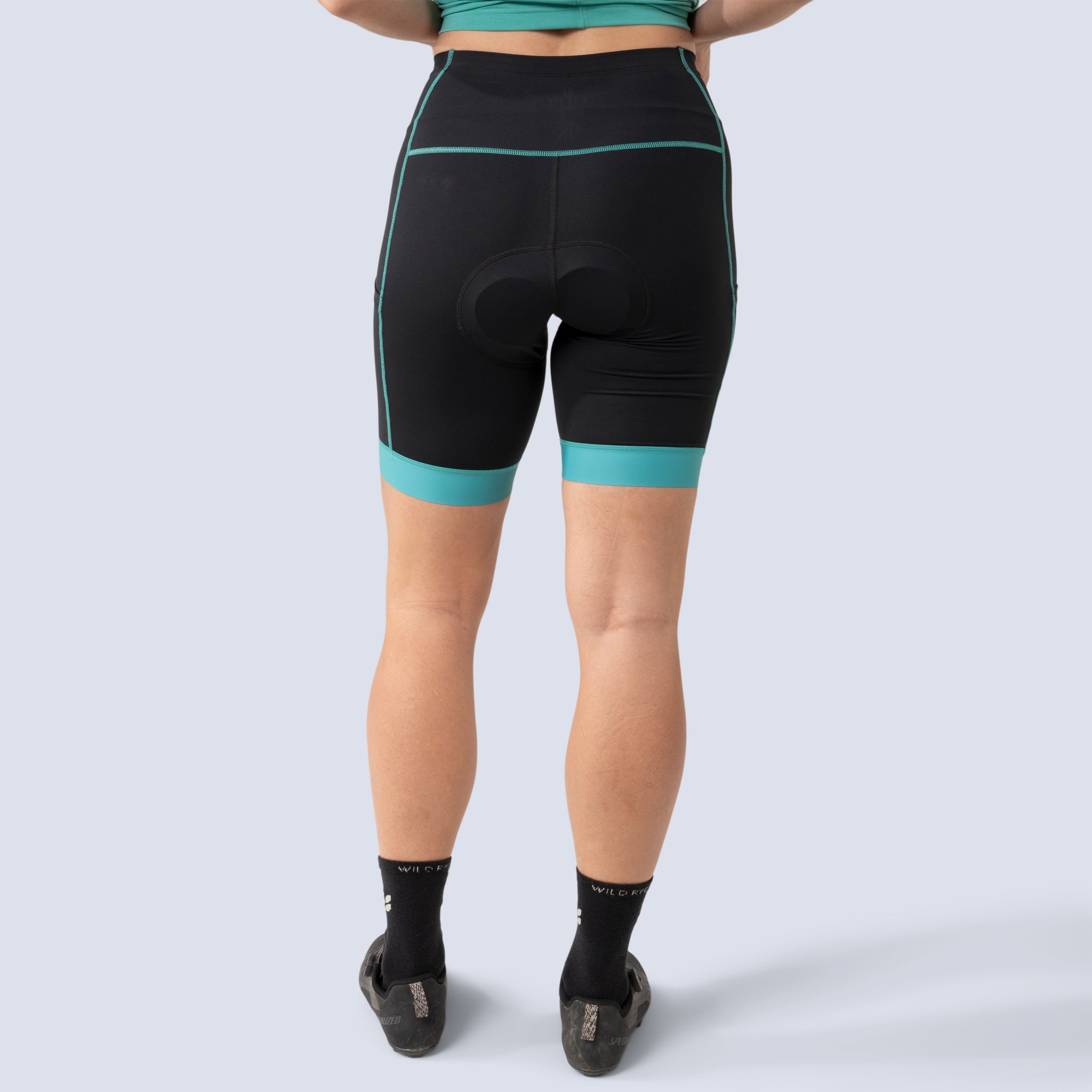 [Black Alhambra Blocked] Alyssa Chammy bike shorts in black with green leg bands, on model back crop view
