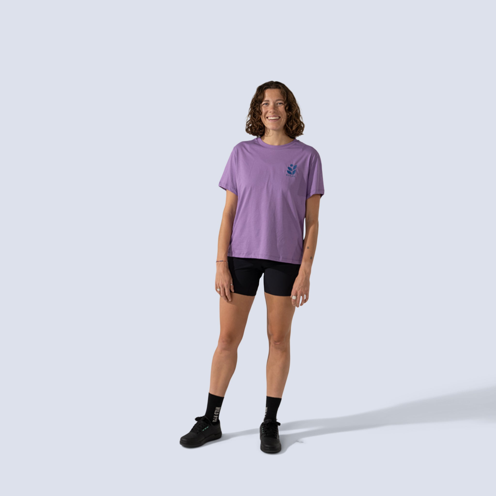 Woman wearing purple t-shirt with an embroidered wild rye logo on chest