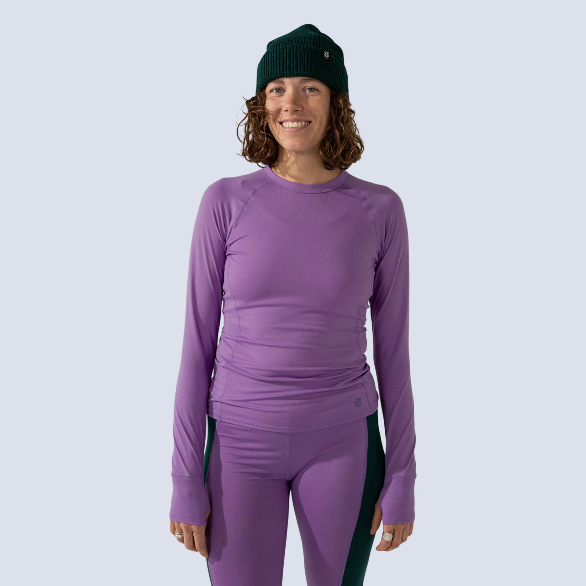 [Shaded Spruce] Person wearing a purple long-sleeve top and leggings with a shaded spruce green beanie 