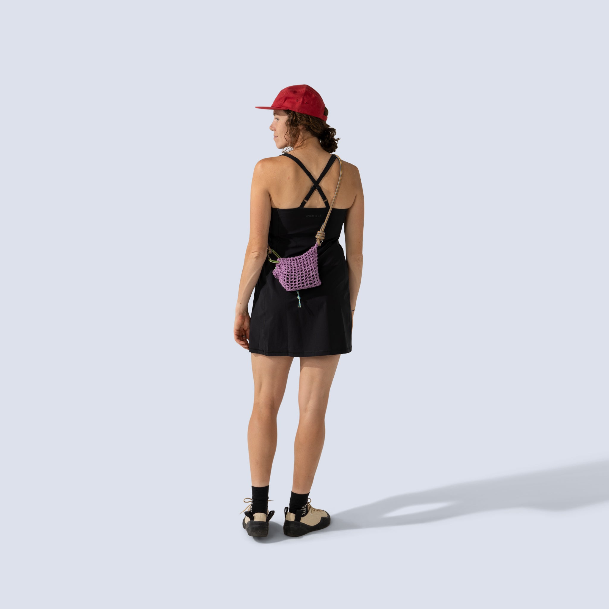 [Black] Woman wearing black Parker dress, and red cap, back view
