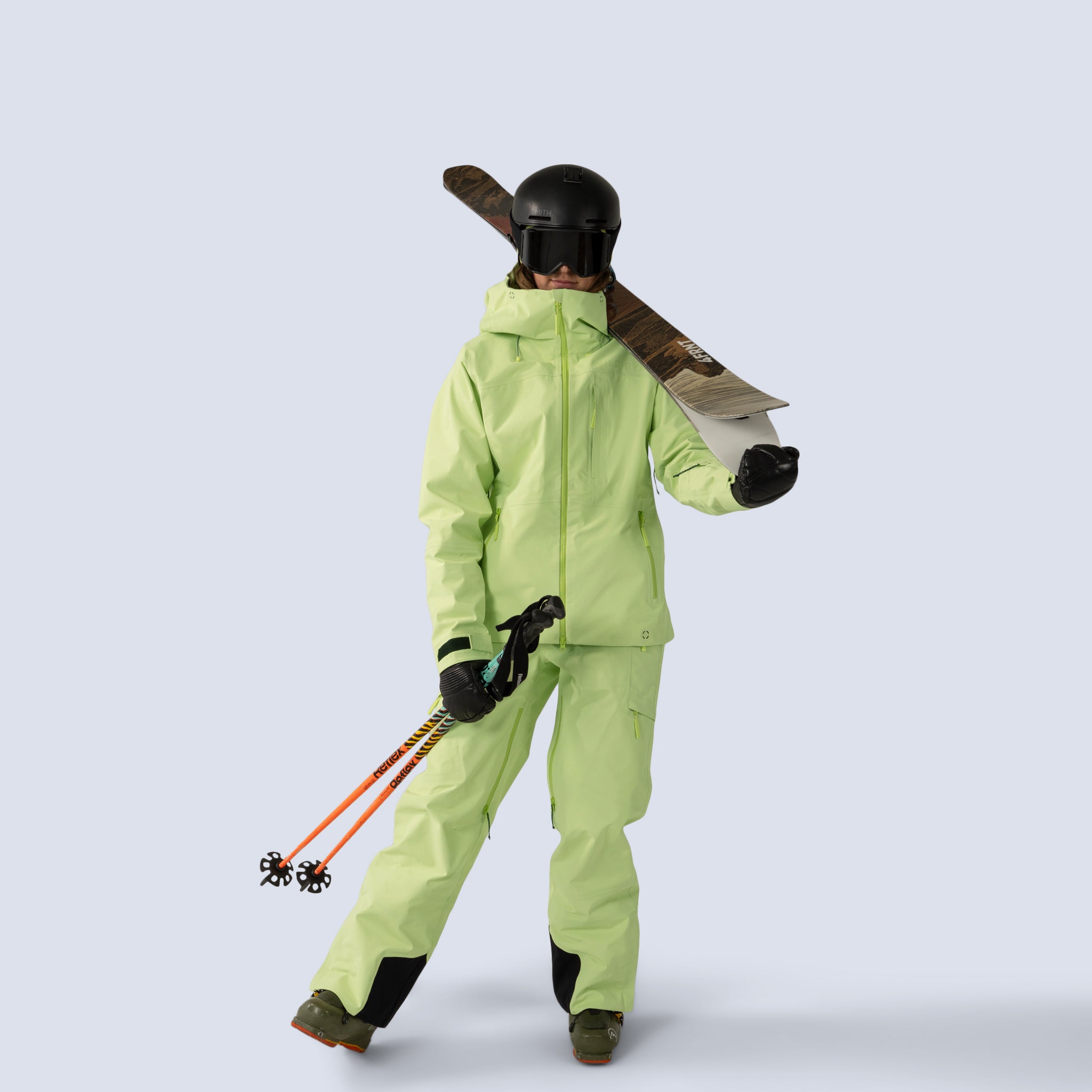 [Iced Matcha] Butterfield 3L pant in iced matcha, on model full body front view with matching jacket, holding skis