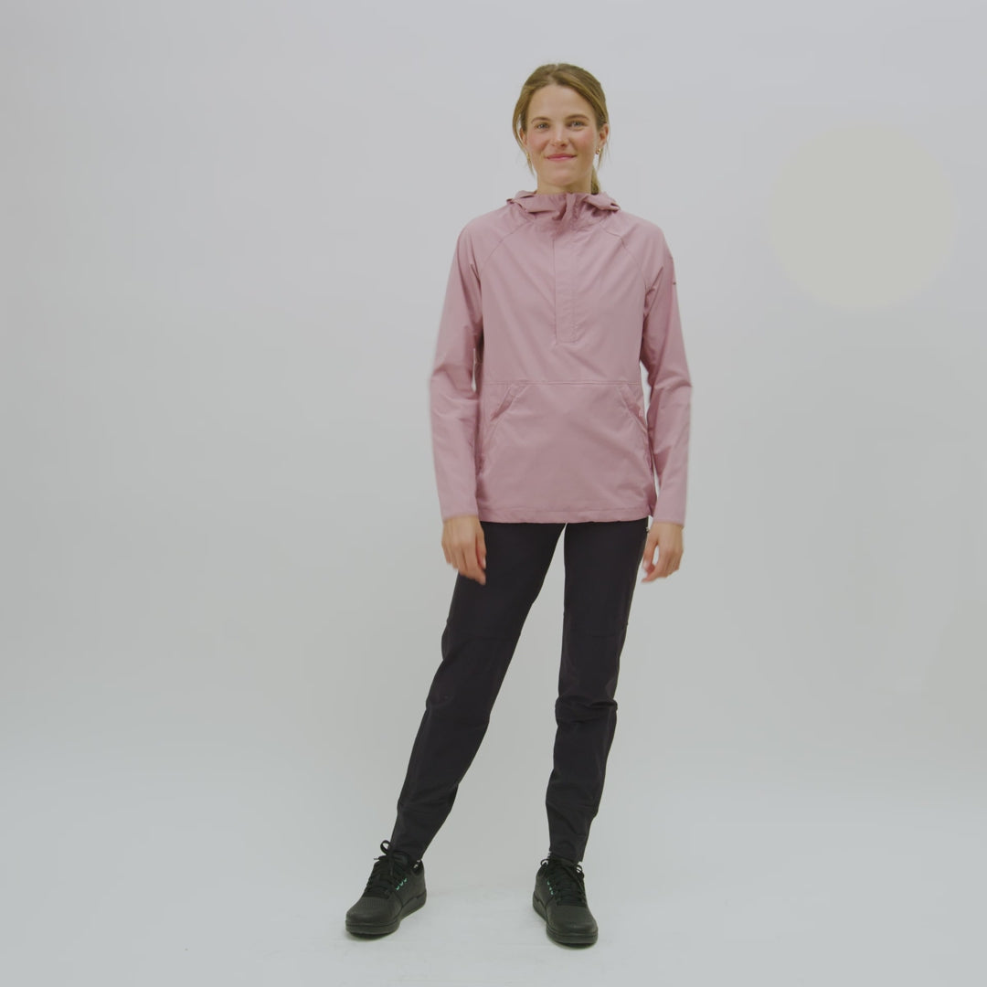 Video of model showing the features of the alden anorak: kangaroo pockets, hem cinch, hood, back air vents, and front zip