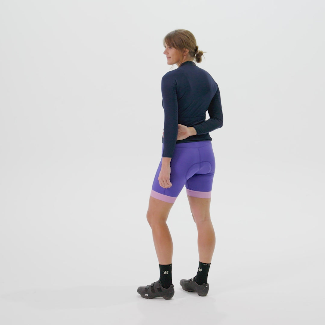 Model showing the features of the gem distance jersey including pockets and hem silicone grip