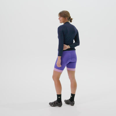 Model showing the features of the gem distance jersey including pockets and hem silicone grip